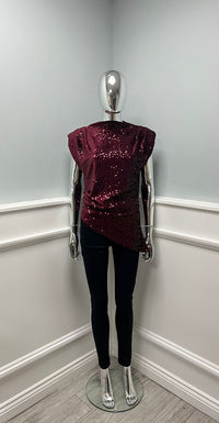 Sleeveless sequin top with padded shoulders and an asymmetric drape hem