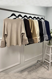 Cream luxe top — soft-touch fabric with plush faux fur cuffs for an elegant winter finish.