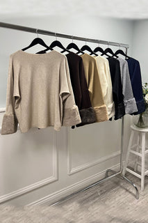 Cream luxe top — soft-touch fabric with plush faux fur cuffs for an elegant winter finish.