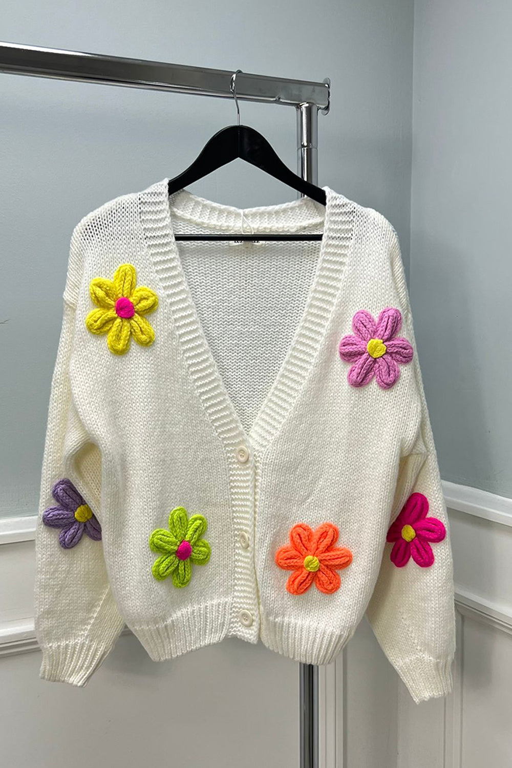 Cardigan – Cozy knit, playful floral details.
