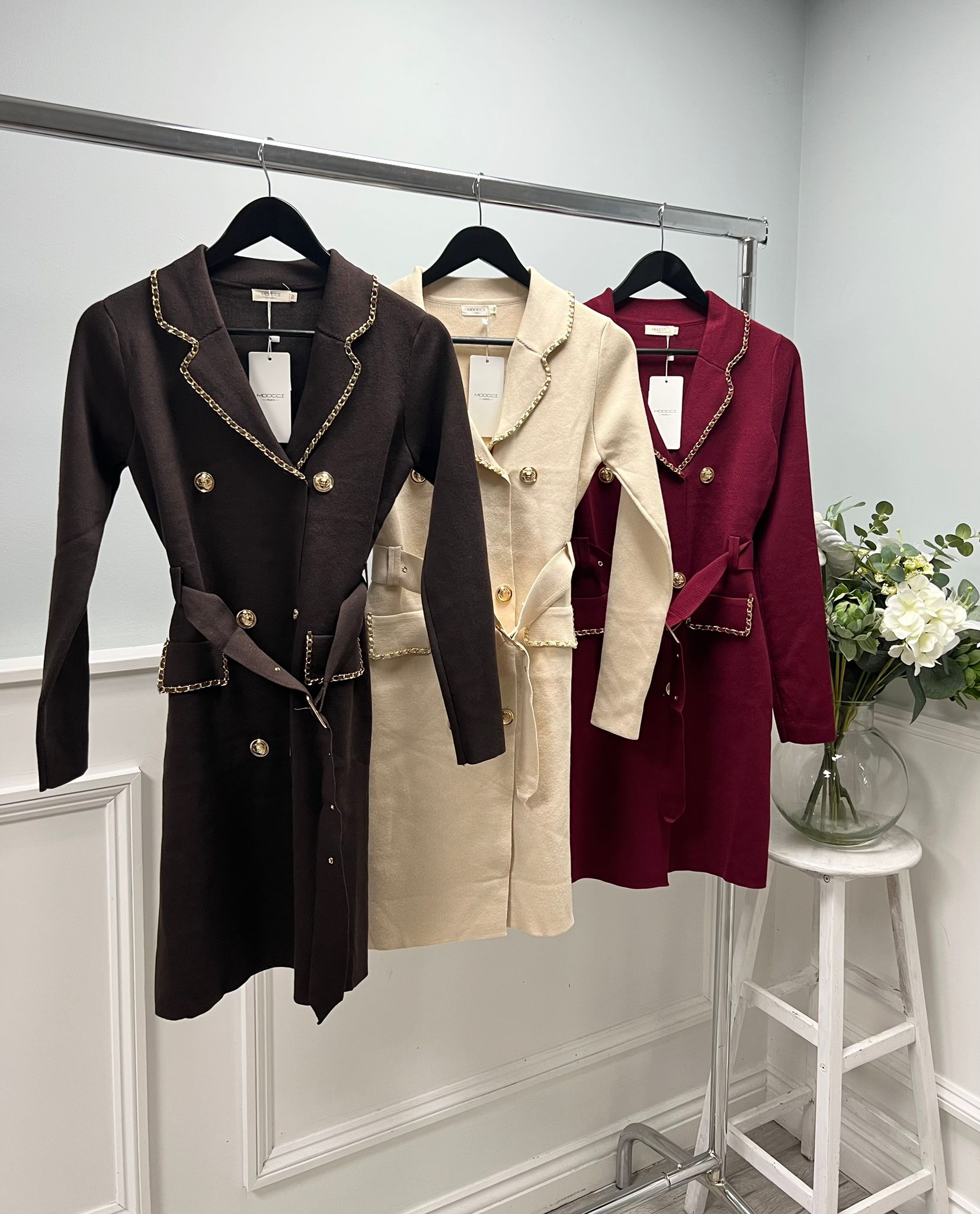 Tailored coat dress with structured shoulders, gold button detailing, and a belted waist