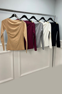 Chic asymmetric long-sleeve top with a draped neckline and gold-tone shoulder detail
